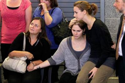 Amanda Knox, center, is comforted by sister Deanna Knox, right, and mother Edda Mellas, left, at a press conference after her return to Seattle. Photo by Stephen Brashear  /  Getty Images 