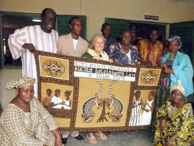 A bogolan banner is presented by the Mayor of Koutial to Maridee Bonadea, on her last trip to Malawi in 2010.