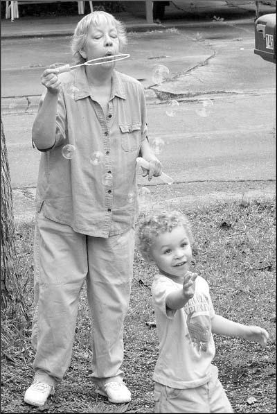 Susan blowing bubbles with her grandson, Ian. Photo by Micheal Boddy.