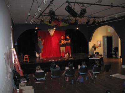 Occupying almost half of the main floor at the Blue Heron Arts Center, the current performing area can barely seat 100 and offers very little buffer for the gallery just to the right of the stage. Stephen Moody (right) teaches comedy and improv on the Blue Heron stage.  