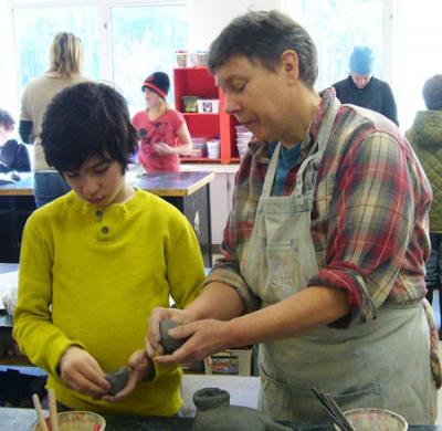 Artist Liz Lewis works with 4th grader Spencer Mazur in sculpting his bird during a VAIS residency, Vashon Shore and Water Birds. All 78 finished birds created by Chautauqua 4th graders will be on display in the window of the Heron’s Nest, April 11-30.