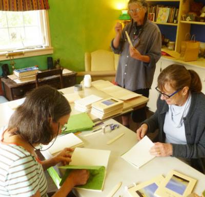 Left to right: Shirley Ferris, Mary Shackelford and Robin Gage work together in Mary’s shop as they assemble her new book, Song In My Belly. Vashon Bookshop hosts a book launch and reading on Thursday, Nov. 12, 6 PM. (Jim Burke photo)