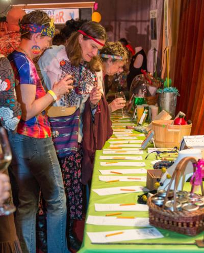 Some groovy chicks thoughtfully peruse items on offer in the silent auction portion of the 2012 Fur Ball event, themed “The Grooviest Fur Ball Ever”. Photo courtesy of John de Groen.