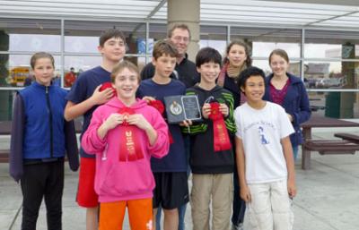 Photo (left to right): Mira Jewell-Peterson (8th), Nick Spranger (7th), Stuart Kraabel (7th), Kieran Enzian (7th), coach Nathan Enzian, Jacob Gold (7th), Rhea Enzian (8th), David Nguyen (8th), and Oakley Reid (8th).