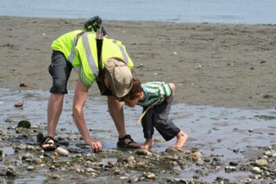 The thrill of discovery!!  Vashon Beach Naturalist Adria Magrath explores the beach with an interested little boy. 2010 Low Tide Celebration. Photo by Jay Holtz.