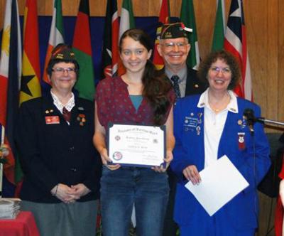 Oakley Reid (center) receives her District award for the Patriot’s Pen youth essay competition