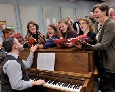 Five soloists featured in Benjamin Britten’s “Ceremony of Carols” practice with the Chorale at a recent rehearsal. (l-r) Shannon Flora, Marita Ericksen, Kaycie Alanis, Sarah Alexander and Amy Holmes. Artistic Director Gary D. Cannon is at the piano. Photo by Rick Wallace.